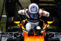 Fernando Alonso, McLaren, lowers himself into the cockpit