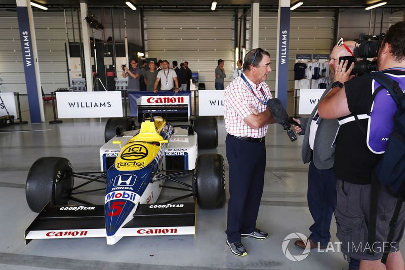 Nigel Mansell is interviewed next to a Williams FW11 Honda