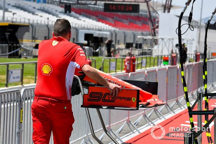 Mecánico de Ferrari empujando el alerón delantero de un Ferrari SF90 