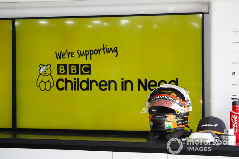 El casco de Stoffel Vandoorne, McLaren, junto a un cartel que indica que el equipo está apoyando a la organización benéfica de la BBC, Children in Need
