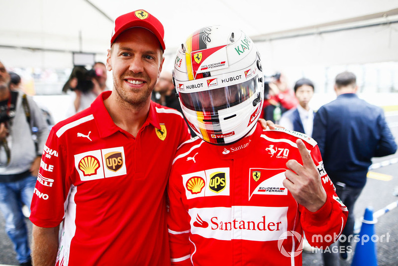 Sebastian Vettel, Ferrari, with a fan wearing a replica helmet.