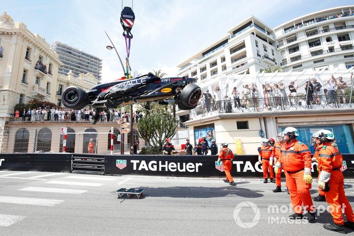 Los comisarios retiran el coche dañado de Sergio Pérez, Red Bull Racing RB20, tras un accidente en la primera vuelta.