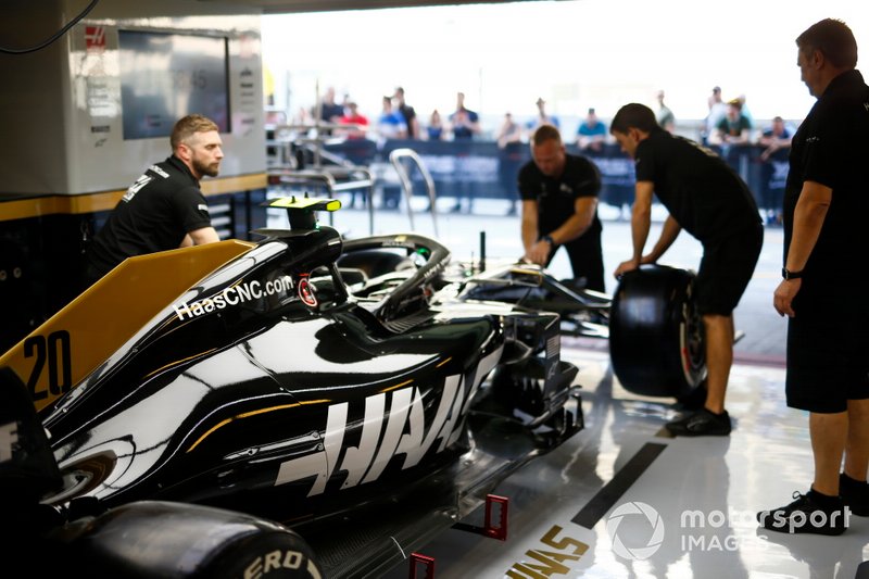 Les mécaniciens travaillent sur la voiture de Kevin Magnussen, Haas F1 Team VF-19 dans le garage