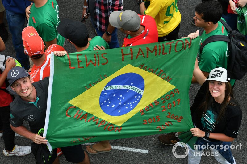 Fans celebrate and display banners after the race