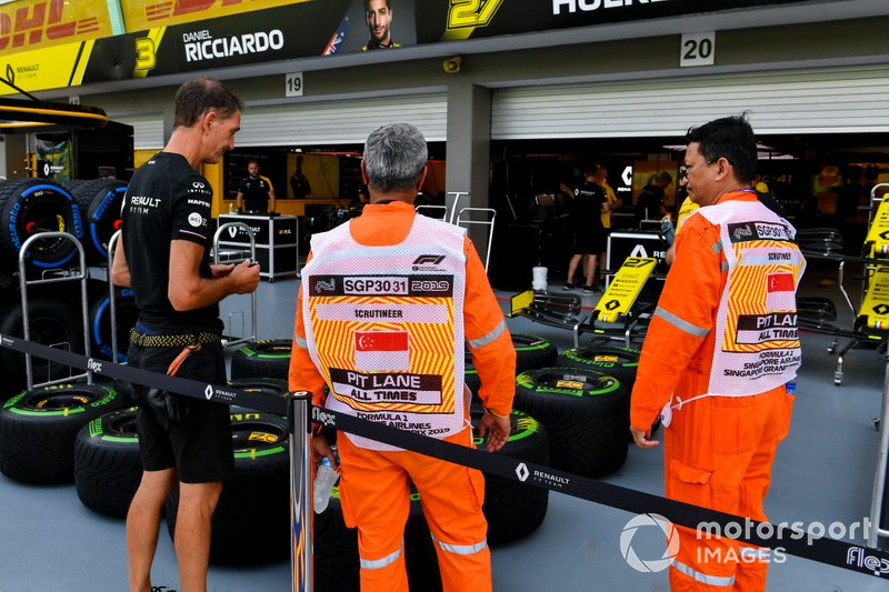 Renault mechanic and scrutineers outside Renault F1 Team garage