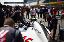 Engineers work on the car of Kevin Magnussen, Haas F1 Team VF-18 Ferrari, on the grid