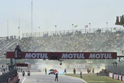 Des fans jettent des fusées de fumée sur la piste au départ