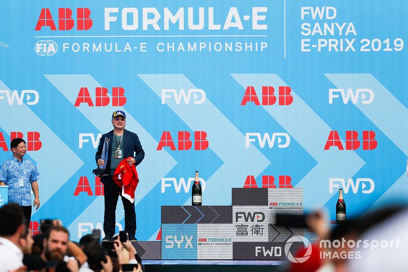 A DS TECHEETAH representative on the podium with the winner's trophy