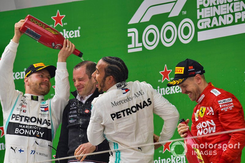 Valtteri Bottas, Mercedes AMG F1, 2nd position, the Mercedes Constructors trophy delegate, Lewis Hamilton, Mercedes AMG F1, 1st position, and Sebastian Vettel, Ferrari, 3rd position, on the dium