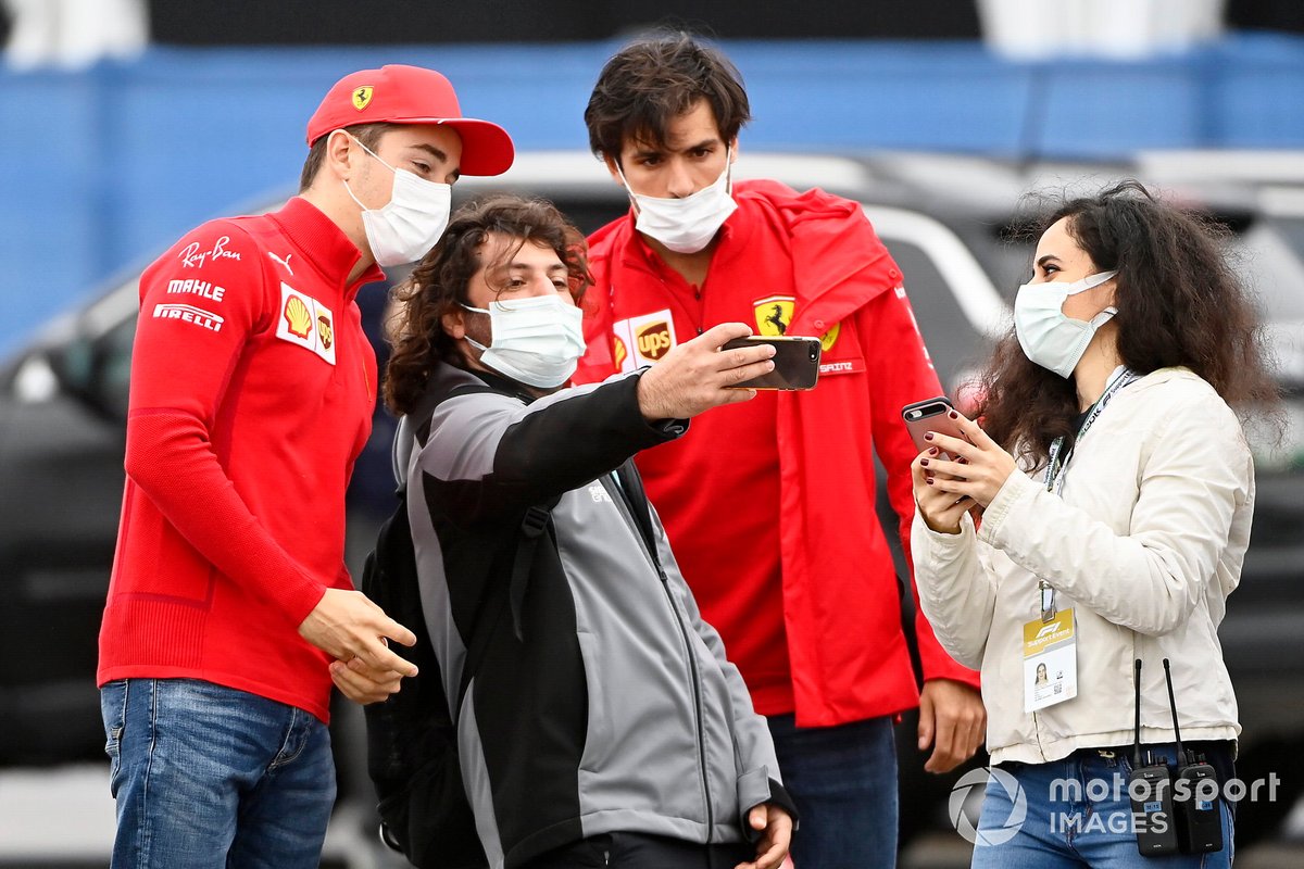 Charles Leclerc, de Ferrari, y Carlos Sainz Jr., de Ferrari, posan con los aficionados para un selfie a su llegada al circuito