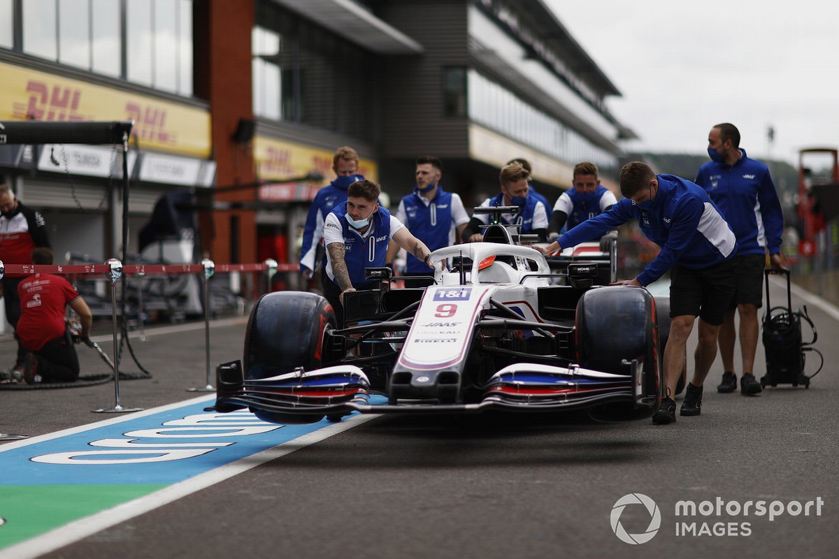 Los mecánicos de Haas F1 empujan el coche de Nikita Mazepin, Haas VF-21 por el pitlane
