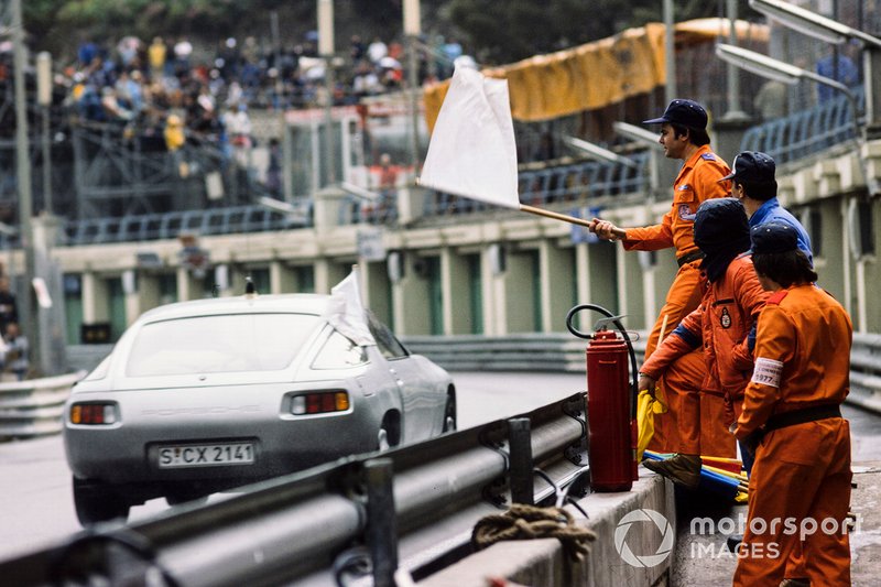 Des commissaires agitent un drapeau blanc alors que le Pace Car passe