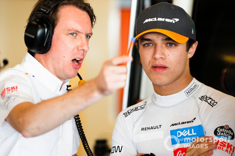Lando Norris, McLaren, talks to his engineer in the garage