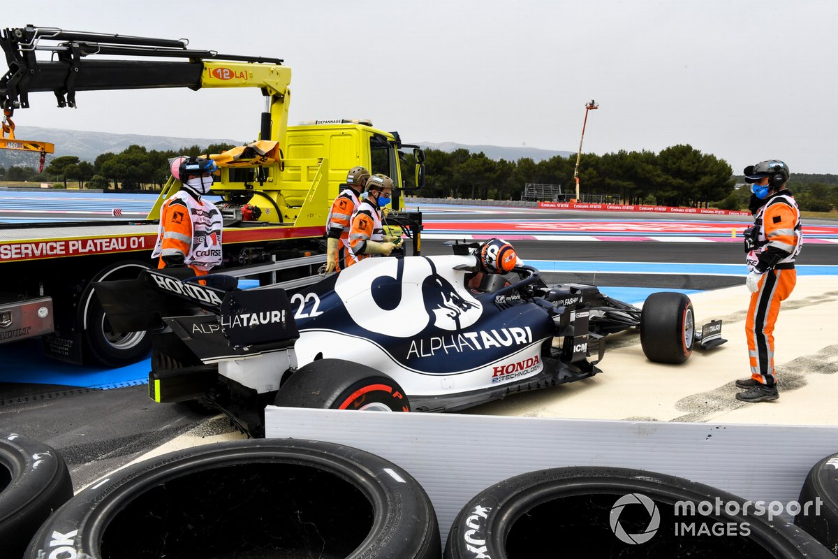Los oficiales de pista asisten a Yuki Tsunoda, AlphaTauri AT02, después de chocar