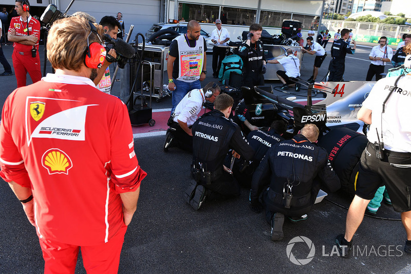 Ingeniero de Ferrari observa el coche de Lewis Hamilton, Mercedes AMG F1 W08