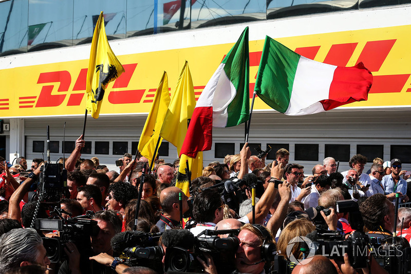 Il team Ferrari festeggia con le bandiere nel parco chiuso