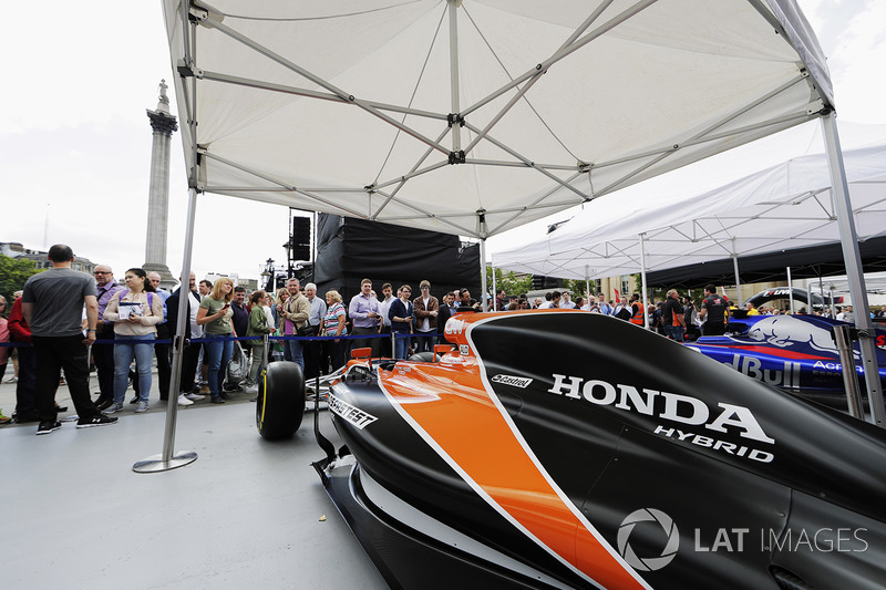 Fans take photos and inspect the McLaren MCL32 on the teams stand