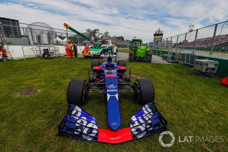 El coche de Carlos Sainz Jr., Scuderia Toro Rosso STR12 es quitado por los oficiales de pista