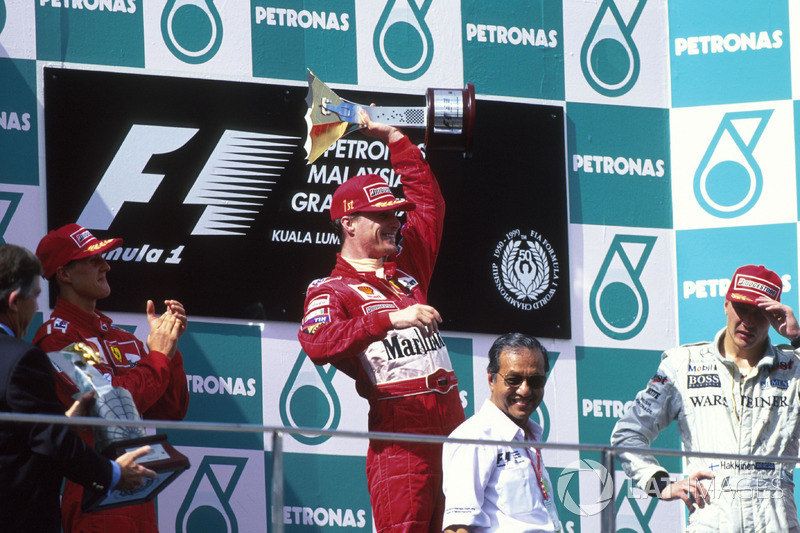 Podium: winnaar Eddie Irvine, Ferrari, tweede Michael Schumacher, derde Mika Hakkinen, McLaren