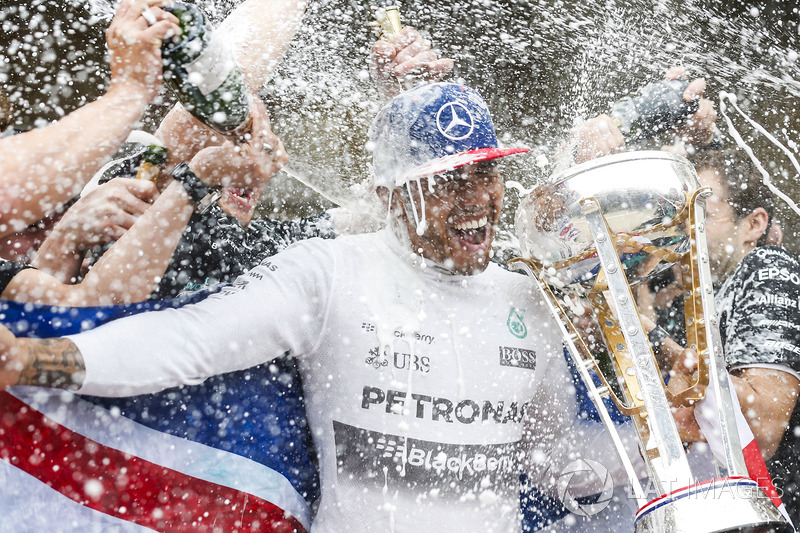 Podium: race winner Lewis Hamilton, Mercedes gets a Champagne soaking from his team after securing a third World Drivers Championship victory