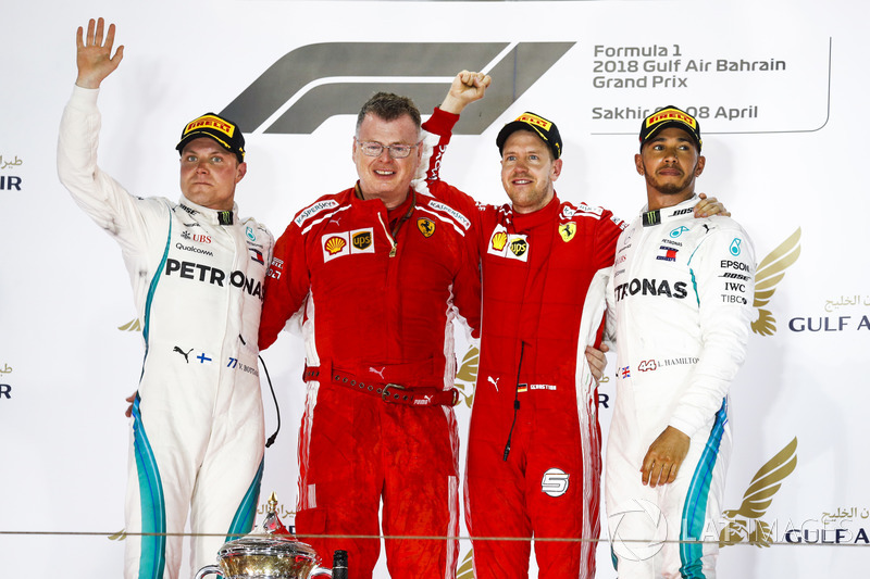 Valtteri Bottas, Mercedes AMG F1, 2° classificato, Sebastian Vettel, Ferrari, 1° classificato, e Lewis Hamilton, Mercedes AMG F1, 3° classificato, sul podio con un membro del team Ferrari che riceve il trofeo Costruttori