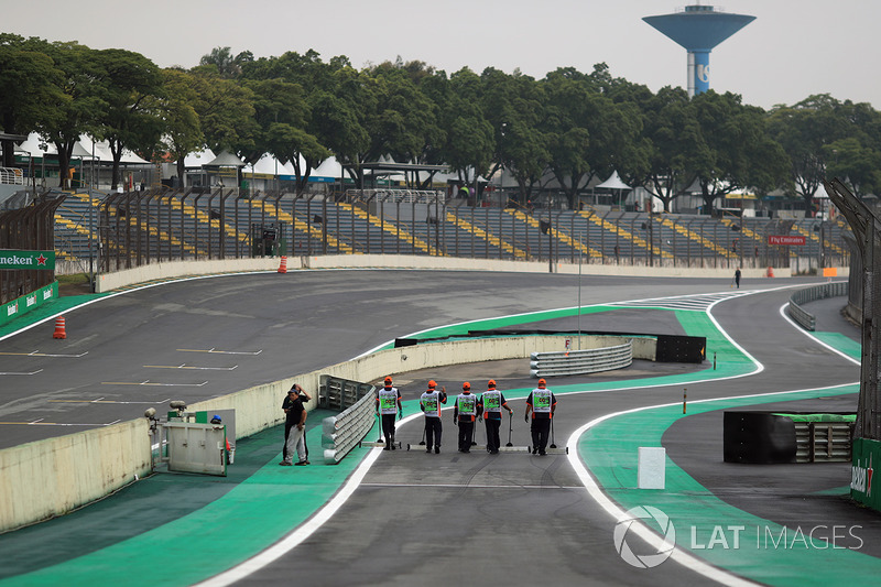 Workers sweep pit lane