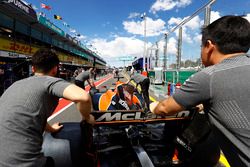 Mecánicos de McLaren empujaN el coche de Fernando Alonso, McLaren MCL32, en el pit lane