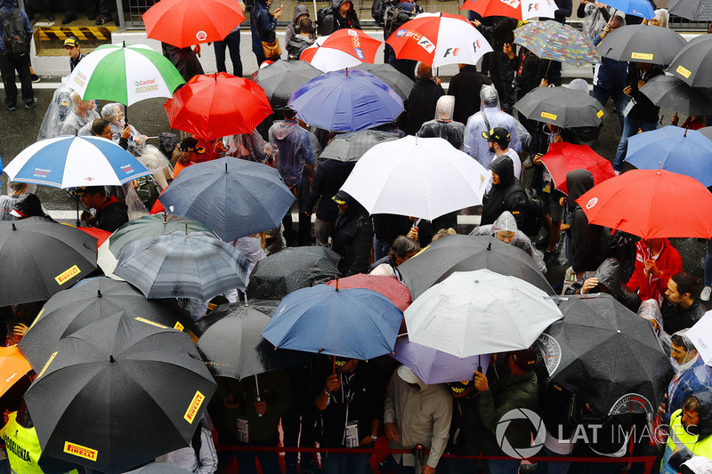 Fans shelter from the rain