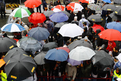Fans shelter from the rain