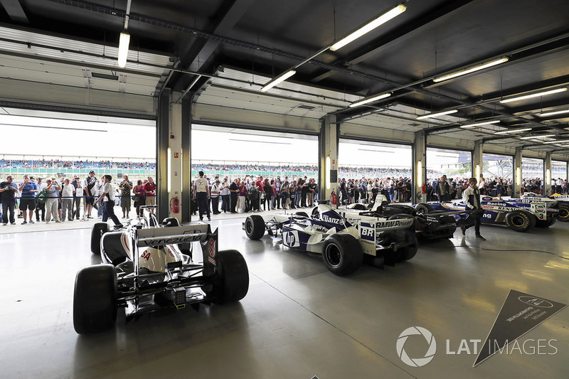 Fans view a garage filled with classic Williams F1 machinery