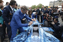 Funzionari e piloti firmano la livrea iceberg su una vettura di Formula E che sarà messa all'asta pe