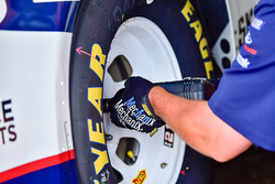 A crew member tightening up a lug nut