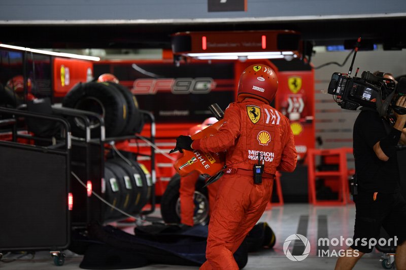 Un membro della pit crew Ferrari con il musetto danneggiato della monoposto di Sebastian Vettel, Ferrari SF90