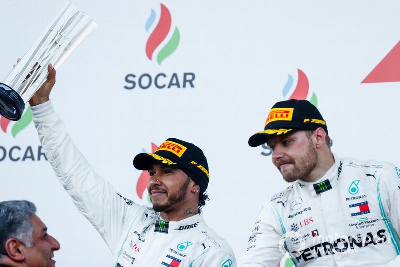 Lewis Hamilton, Mercedes AMG F1, 2nd position, receives his trophy alongside Valtteri Bottas, Mercedes AMG F1, 1st position, on the podium