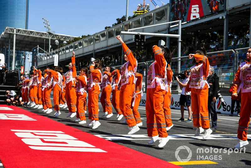 Les commissaires dansent lors de la parade des pilotes