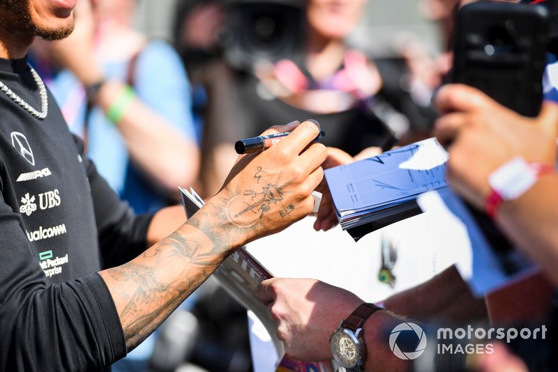 Hands of Lewis Hamilton, Mercedes AMG F1 signing an autograph for a fan