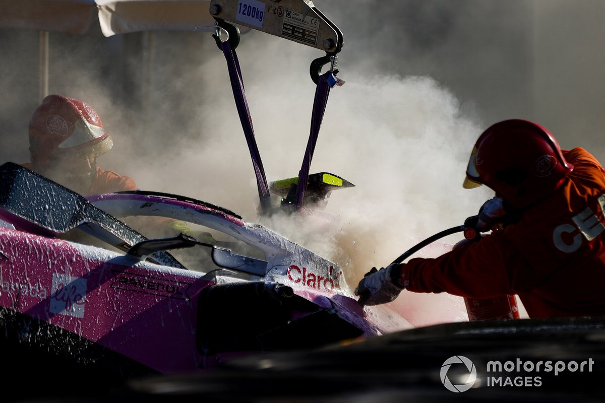 Fire marshals extinguish the car of Lance Stroll, Racing Point RP20