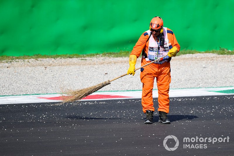 El oficial de pista barre la pista con un cepillo