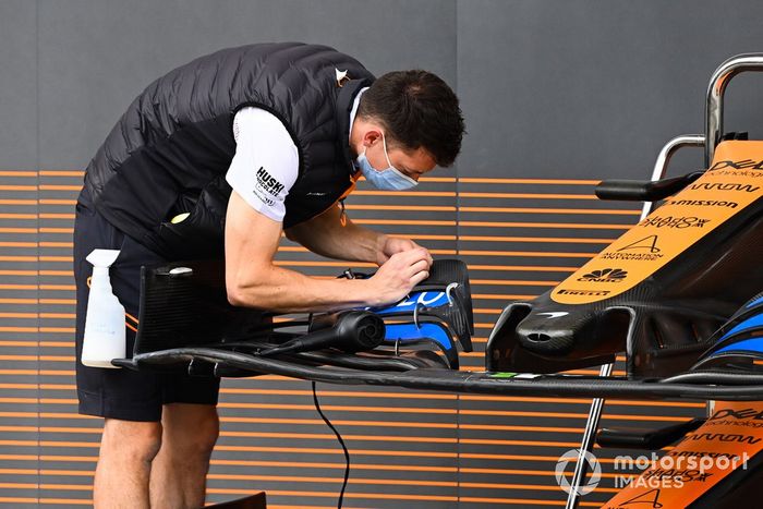 Un mecánico de McLaren trabajando en la endplate del alerón delantero