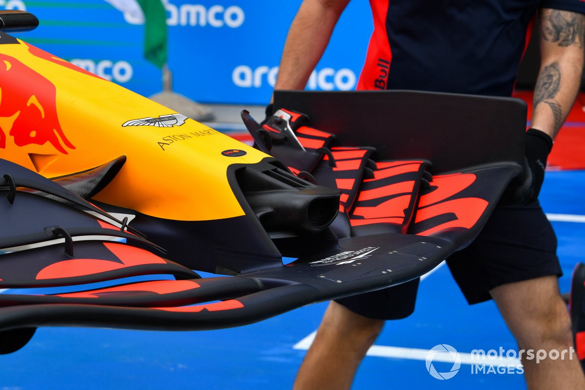 Mechanics rush to replace the damaged front wing of Max Verstappen, Red Bull Racing RB18