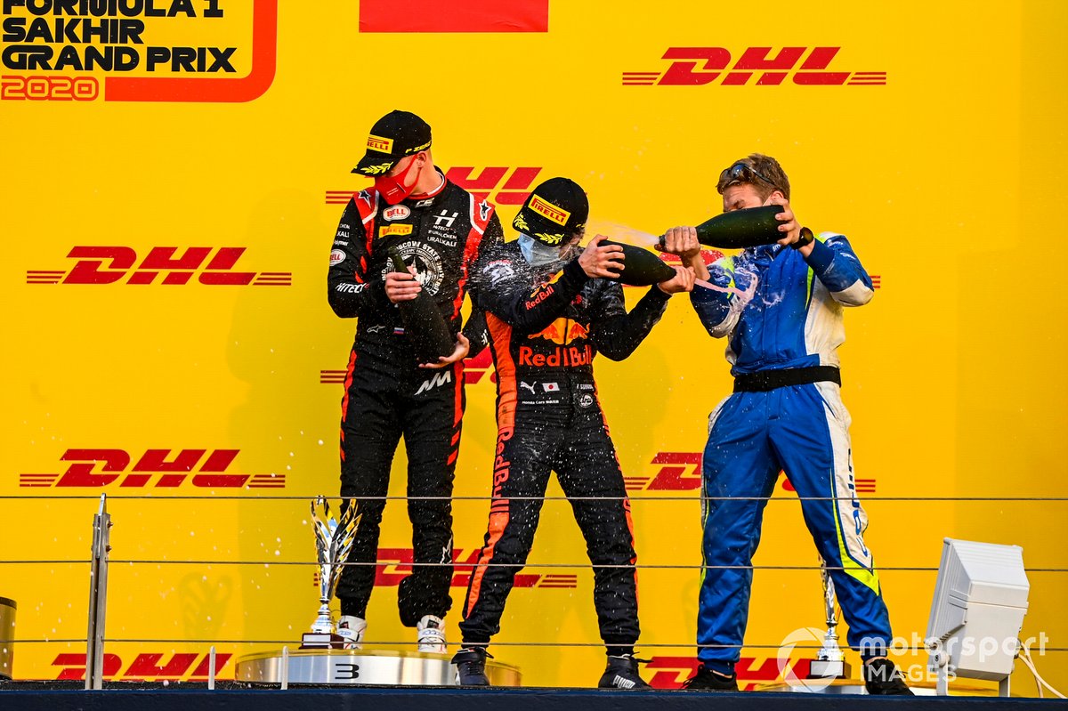 Nikita Mazepin, Hitech Grand Prix, 3rd position, and Yuki Tsunoda, Carlin, 1st position, spray champagne on the podium