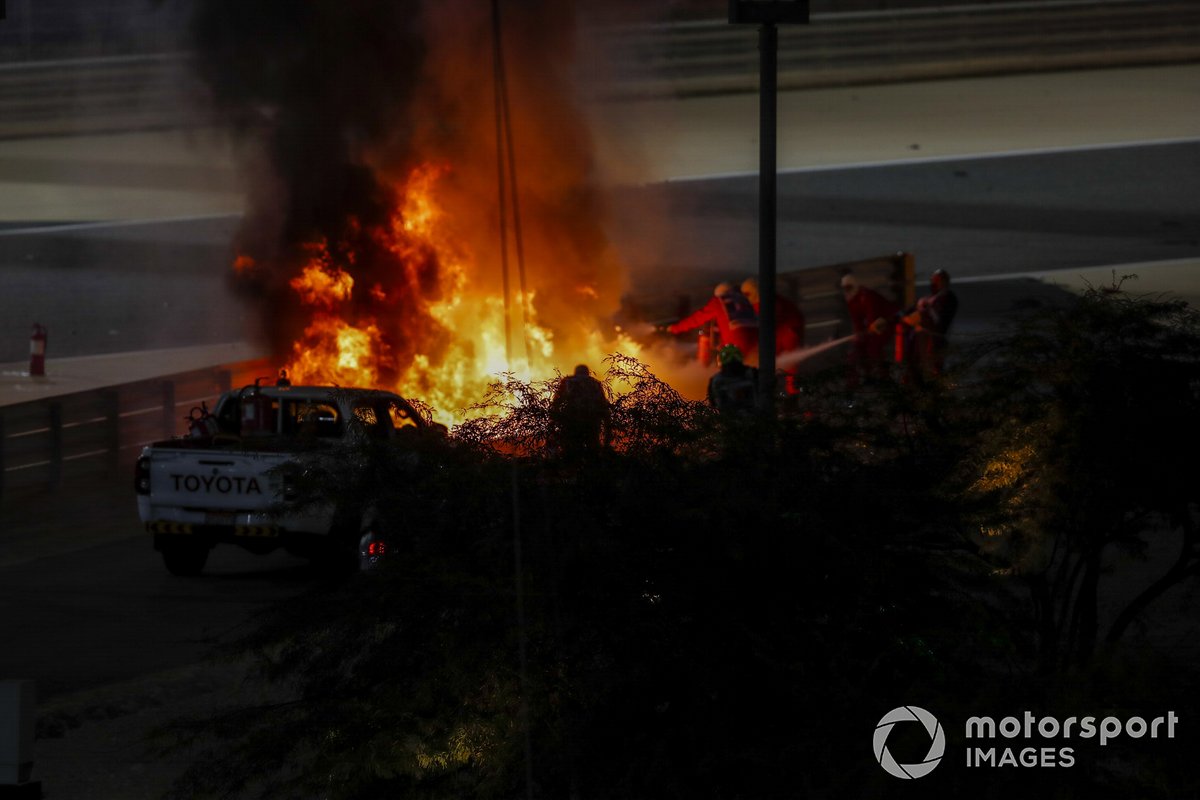 Fire marshals deal with the flames after a huge crash for Romain Grosjean, Haas VF-20, on the opening lap