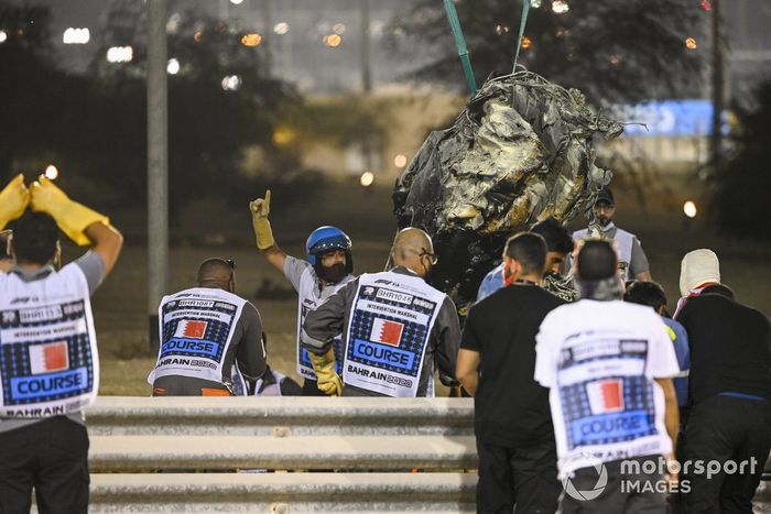 Los oficiales retiran los restos del monoplaza de Romain Grosjean, Haas VF-20, después del accidente en la primera vuelta