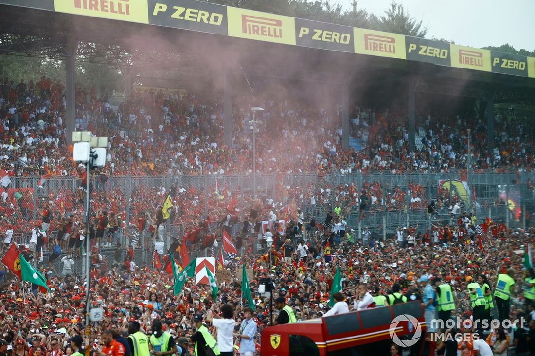 El humo rojo llena el aire mientras la multitud celebra la victoria de Ferrari.