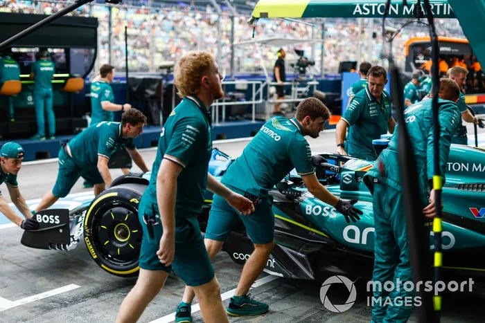 Los mecánicos empujan a Fernando Alonso, Aston Martin AMR24, de vuelta al garaje