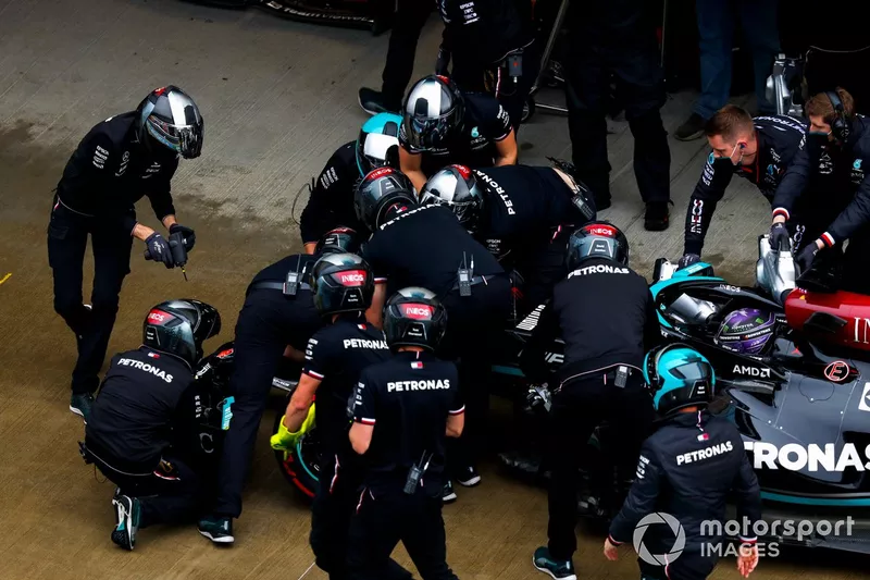 El equipo de boxes de Mercedes trabaja en el alerón delantero de Lewis Hamilton, Mercedes W12, en el pit lane