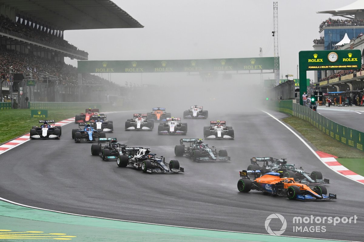 Lando Norris, McLaren MCL35M, Lance Stroll, Aston Martin AMR21, Yuki Tsunoda, AlphaTauri AT02, Sebastian Vettel, Aston Martin AMR21, Lewis Hamilton, Mercedes W12, and the remainder of the field at the start