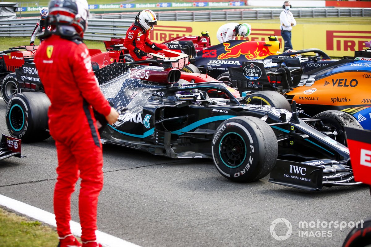 Charles Leclerc, Ferrari in Parc Ferme mira el neumático dañado del monoplaza de Lewis Hamilton, Mercedes F1 W11