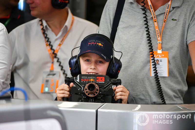 Юный гость в гараже Red Bull Racing с рулем Макса Ферстаппена