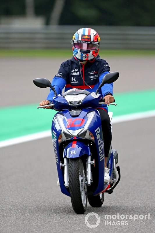 Pierre Gasly, Toro Rosso STR14, rides a scooter